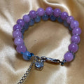 amethyst beaded bracelet with a steel clasp on a satin background