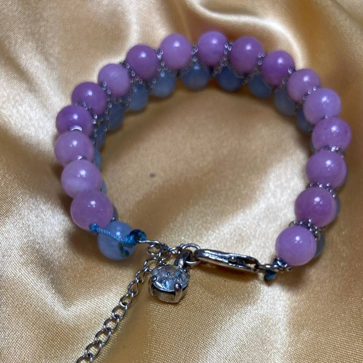 amethyst beaded bracelet with a steel clasp on a satin background
