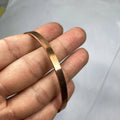 Copper bracelet on a person's wrist against a white background