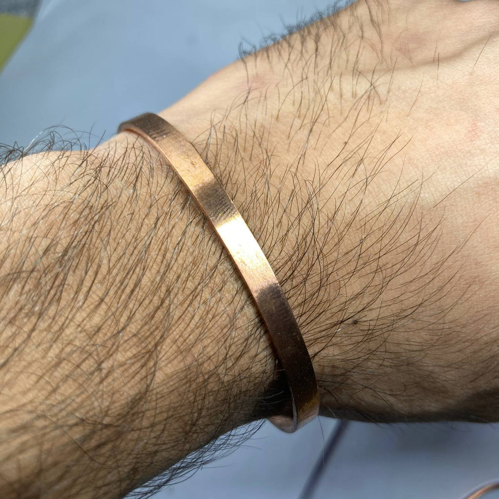 Close-up of a copper bracelet on a wrist with a blurred background