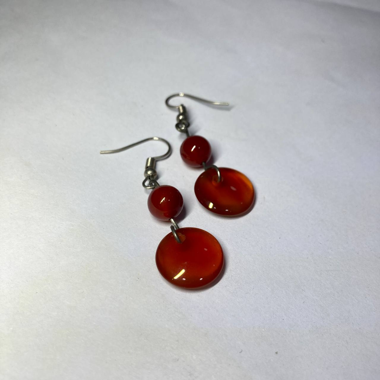 Pair of red circular earrings on a white background