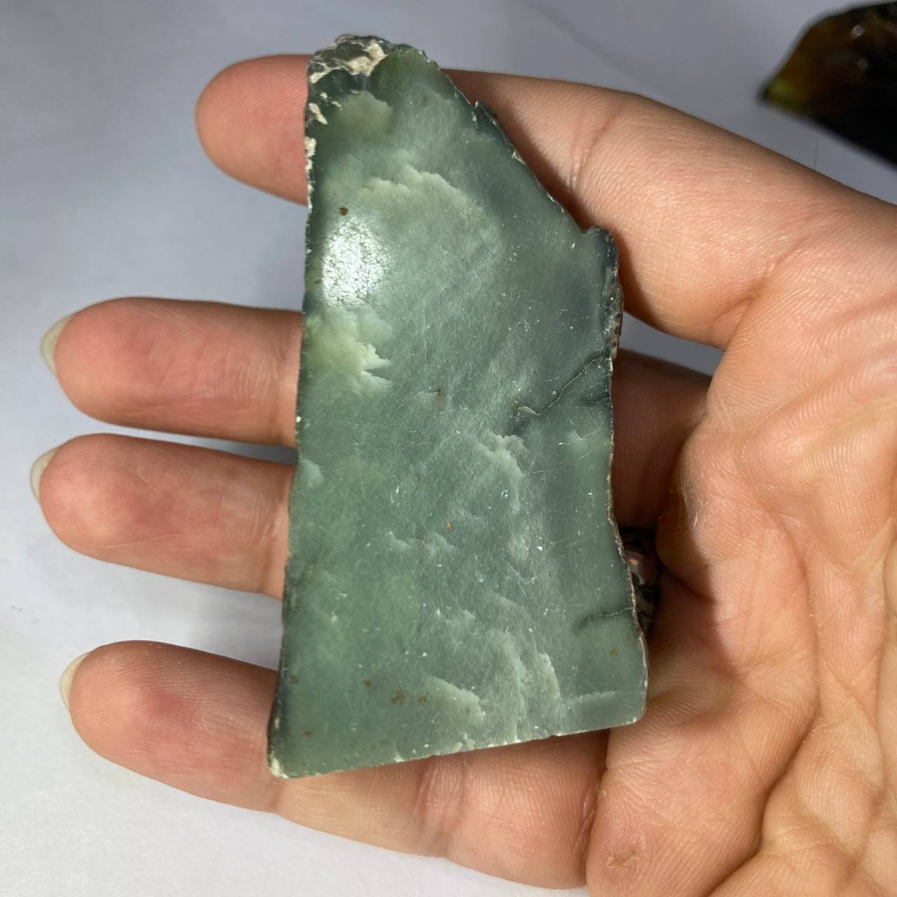 Hand holding a natural polished jade 