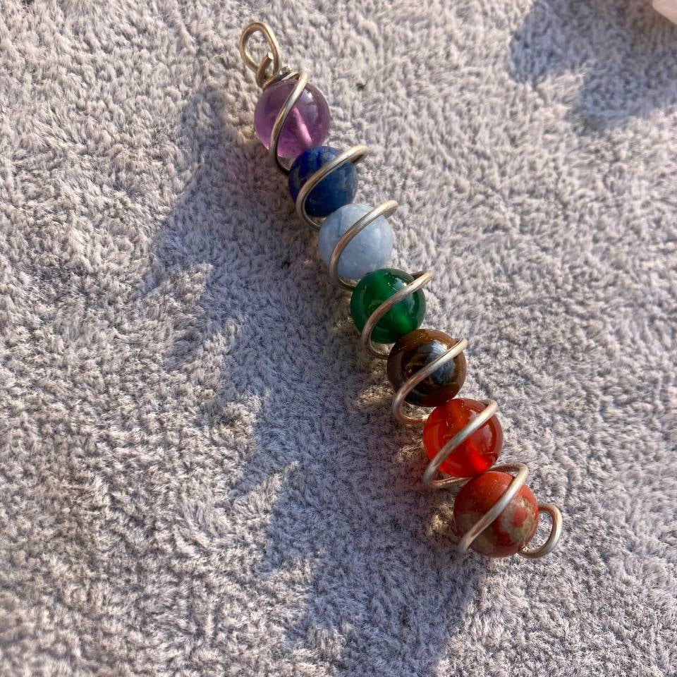 Multicolored beaded pendant on a textured surface