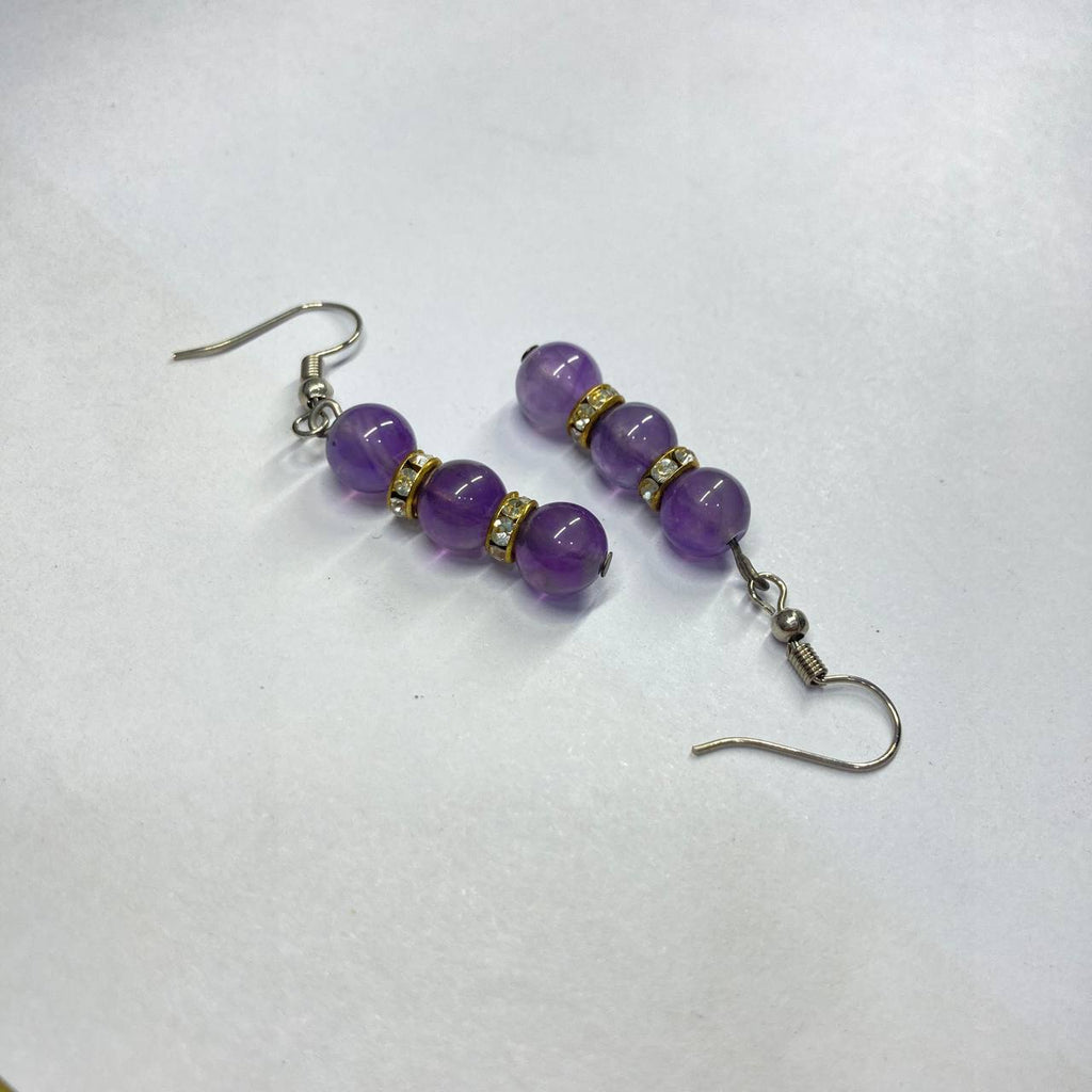 Purple beaded earrings on a white background
