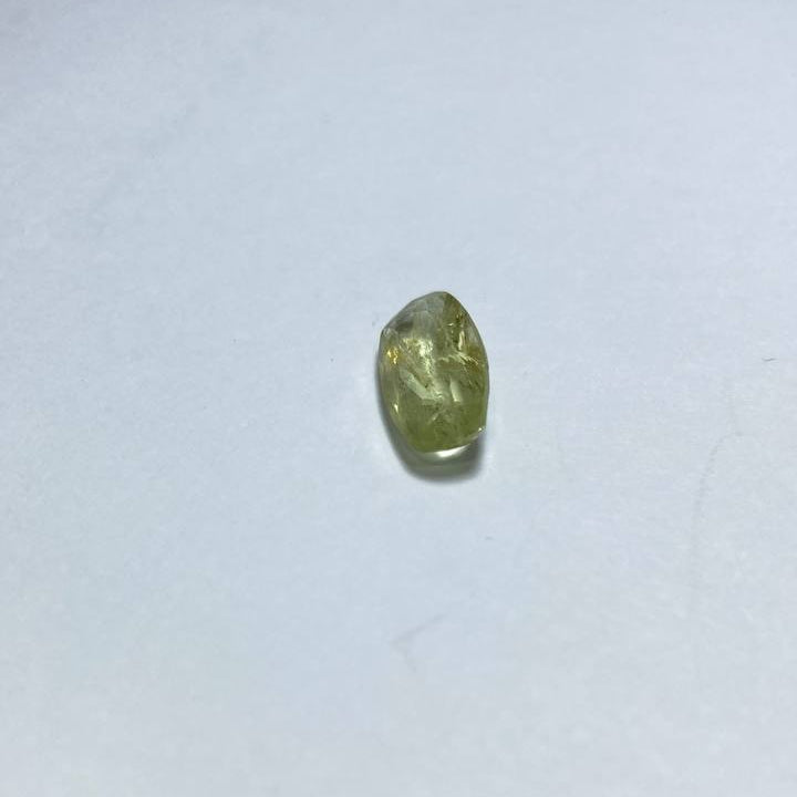 Small greenish object on a white surface