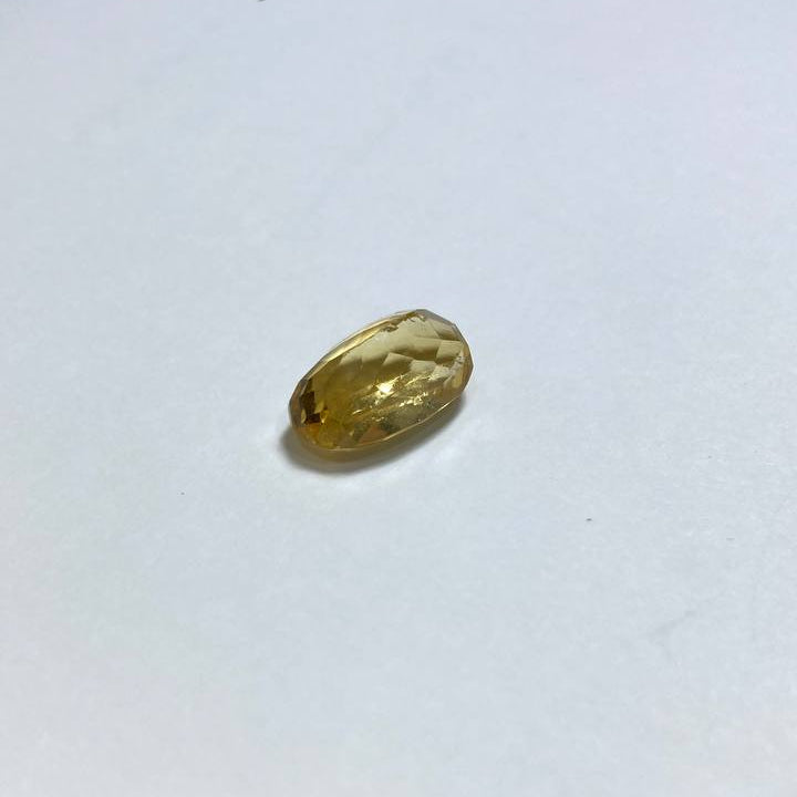 Small gold gemstone on a white surface
