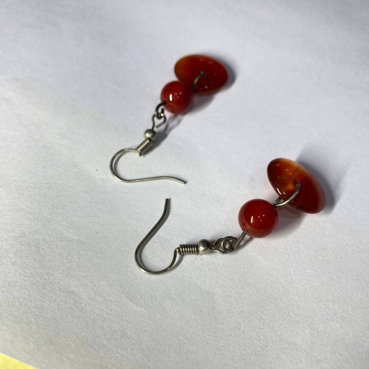 Pair of earrings with red beads on a white background