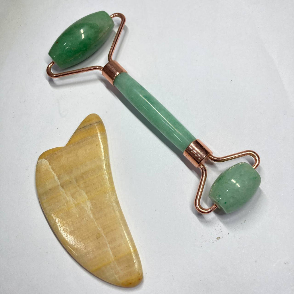 Jade facial roller and gua sha tool on a white background
