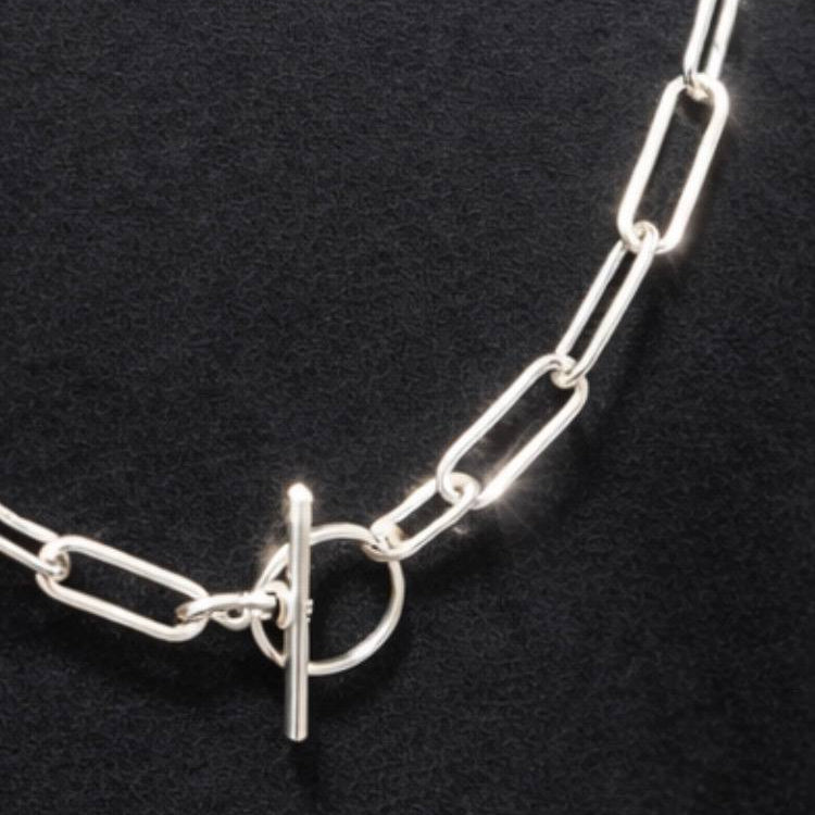 Silver chain necklace with a clasp on a black background