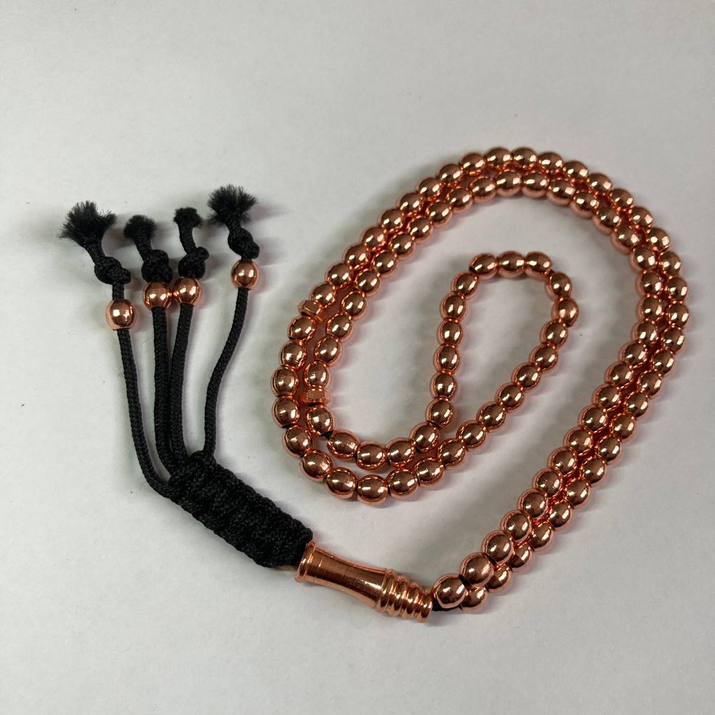A copper beaded rosary with a black cord tassel and a metallic copper collar, displayed on a light gray background.