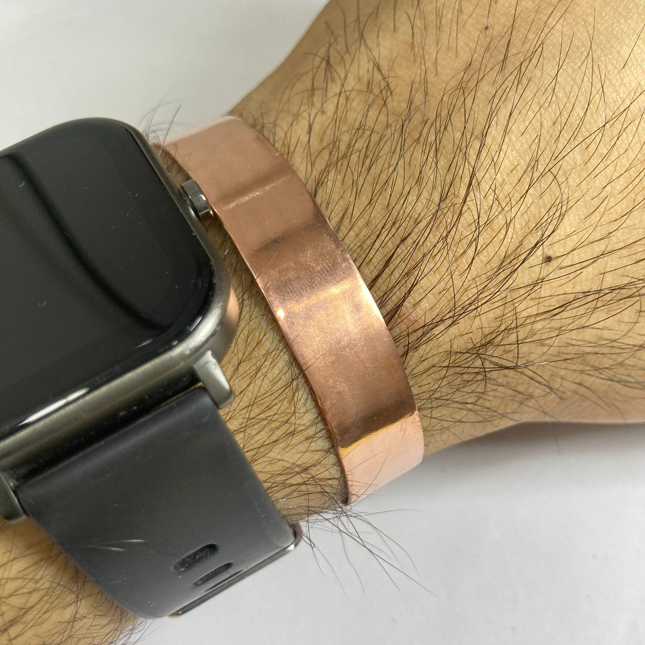Smartwatch with a copper band on a wrist against a white background