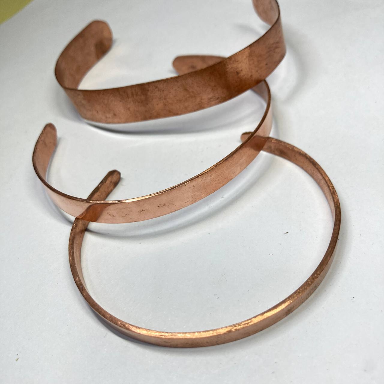 Two copper bracelets on a white background