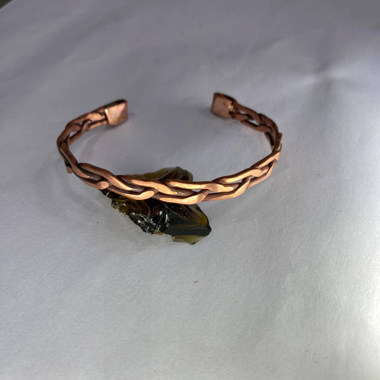 Copper bracelet with a stone on a white background